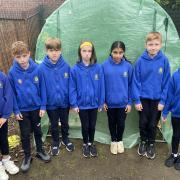 Year 5 and 6 Children of the school's Eco Council in front of the vandalised greenhouse