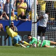 Bolton Wanderers' James Trafford saves at the feet of Sheffield Wednesday's Dennis Adeniran with Bolton Wanderers' Ricardo Santos close by