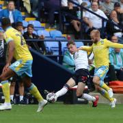 Bolton Wanderers' Conor Bradley plays a forward pass under pressure from Sheffield Wednesday's Barry Bannan