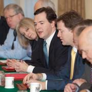 Theresa May listens as Chancellor George Osborne addresses a Cabinet meeting ahead of the Comprehensive Spending Review announcement