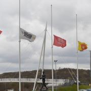The University of Bolton Stadium with flags at half mast.