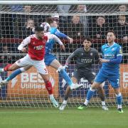 Conor Bradley goes up for a header with Danny Andrew in Wanderers' 2-1 win at Fleetwood