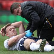 George Johnston is treated by physio Matt Barrass after hurting his ankle at Charlton