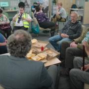 The Monty men and Yvonne sit around a table in the 'Sheffield Job Hub', played by Bolton's former Specsavers in Crompton House
