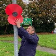 Councillor Neil Maher, a Falklands War veteran, putting up a street poppy in Westhoughton on a previous year