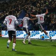 Dan Nlundulu leaps into the air to celebrate scoring Bolton's seventh goal against Exeter