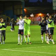 Wanderers players celebrate their win against Carlisle with the travelling supporters