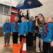 The Scouts group under umbrellas in the building