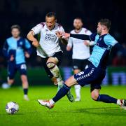 Derby County's Kane Wilson (left) and Wycombe Wanderers' Matt Butcher battle for the ball during the Sky Bet League One match at Adams Park, Wycombe