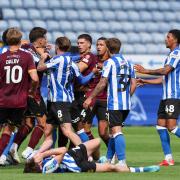 Harry Gray lies on the floor as players from both sides scuffle following the red card incident
