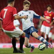 Bury's Henry Wordingham tries to get past Manchester United's Joe Riley during the first half at Old Trafford.
