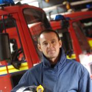 ON DUTY: Neil Mercer kitted out for his day job as watch manager at Bolton Central fire station