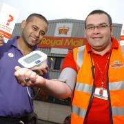 Post office worker Michael Barnes, right, has his blood pressure checked by NHS trainer Jay Ahmed