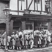 JOIN THE QUEUE: Young and old wait to get inside the Sabini Brothers cafe in Bolton’s during the 1930s