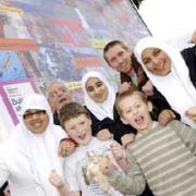 ART FOR ALL: Artist Oliver Wotherspoon, back right,  and Cllr Noel Spencer, back left, with youngsters at a community billboard off Great Moor Street, Bolton