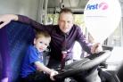 Matt Rawlinson, First Buses’ business manager, lets Owen Davies, aged three, from Farnworth, try out the wheel of a bus during the event in Victoria square